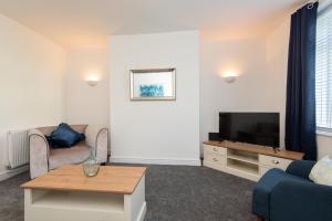 a living room with a couch and a tv at Richardson Place in Kirk Merrington