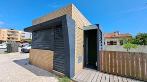 a small house with a black door and a wooden fence at Kiosk 550 Apartment - Póvoa de Varzim in Póvoa de Varzim +6 photos