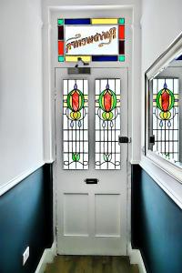 波斯馬多格的住宿－Porthmadog, Sleeps 11, 5 Bedrooms, 5 Bathrooms, Mountain Views，走廊上设有彩色玻璃窗的白色门