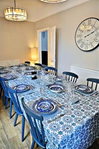 Zimmer mit einem Tisch mit blauen und weißen Platten und einer Uhr in der Unterkunft Porthmadog, Sleeps 11, 5 Bedrooms, 5 Bathrooms, Mountain Views in Porthmadog
