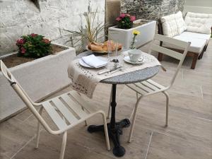 uma pequena mesa com duas cadeiras e uma mesa com uma chávena de café em Villa Buffon em Angers