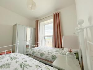 a bedroom with two beds and a window at Porthmadog, Sleeps 11, 5 Bedrooms, 5 Bathrooms, Mountain Views in Porthmadog