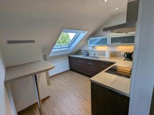 a small kitchen with a large window and a counter at S'bahnhöfle Apartments in Ringsheim