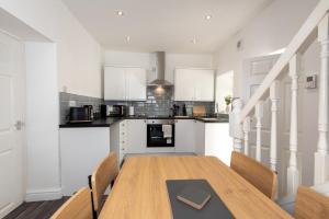 a kitchen and dining room with a wooden table and chairs at Richardson Place in Kirk Merrington