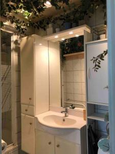a white bathroom with a sink and a mirror at Studio Zeezucht in Blankenberge
