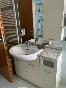 a white bathroom with a sink and a mirror at EDYSHOME in Peschiera del Garda