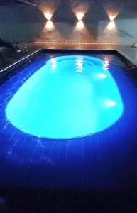 a large blue swimming pool with lights on it at Bela Casa Hostel in Ji-Paraná