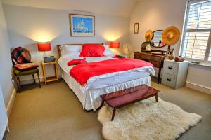 a bedroom with a large bed with a red blanket at Finest Retreats - Kings Wharf - Luxury Riverside Home in Burnham-on-Crouch