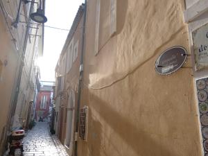 un callejón estrecho con señales en el lateral de un edificio en GiuattyHomeHoliday Termoli, en Termoli