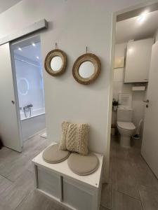 a bathroom with a toilet and two mirrors on the wall at Appartement Lena in Linz