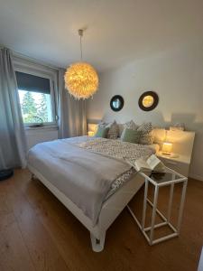 a bedroom with a large bed and a chandelier at Appartement Lena in Linz