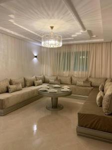 a living room with a couch and a table at Apartment Tanger Achakar with pool nearby sea in Tangier