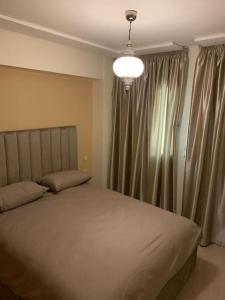 a bedroom with a bed and a window with curtains at Apartment Tanger Achakar with pool nearby sea in Tangier