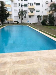 a large blue swimming pool in front of a building at Apartment Tanger Achakar with pool nearby sea in Tangier