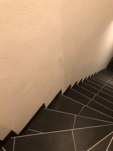 uma escada numa casa de banho com azulejos pretos em Eine 2 Zimmer Ferienwohnung Münster City em Münster