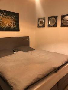 ein Bett in einem Schlafzimmer mit drei Bildern an der Wand in der Unterkunft Eine 2 Zimmer Ferienwohnung Münster City in Münster
