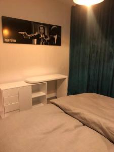 Schlafzimmer mit einem Bett, einem Schreibtisch und einem Bild in der Unterkunft Eine 2 Zimmer Ferienwohnung Münster City in Münster