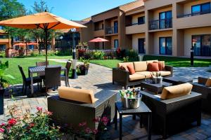 an outdoor patio with tables and chairs and an umbrella at Courtyard by Marriott Chicago Naperville in Naperville