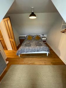 a bedroom with a bed with a gray comforter at Meadow View @ Glebe Barn in Pershore