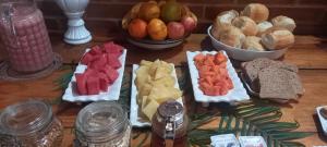 uma mesa com diferentes tipos de pão e fruta em Pousada Zoe em Pirenópolis
