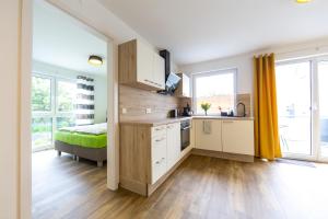 uma cozinha com armários brancos e uma cama num quarto em Ferienwohnungen Rhönhimmel em Gersfeld