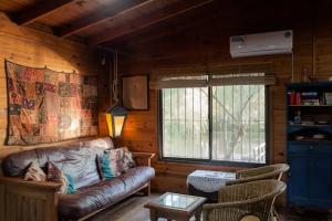 una sala de estar con un sofá de cuero en una cabaña en Casa isleña Extasis Propio en Tigre