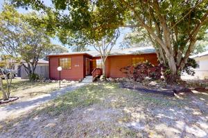 a red house with a tree in front of it at Jupiter Pines Cottage in Clearwater
