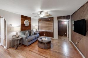 a living room with a couch and a tv at Jupiter Pines Cottage in Clearwater