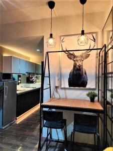 a kitchen with a table and a picture of a deer at Air Residences Airbnb in Manila