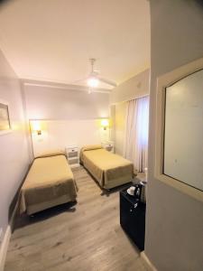 um quarto de hotel com duas camas e uma televisão de ecrã plano em Prince Hotel em Mar del Plata