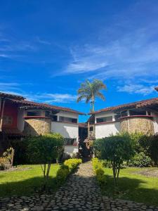 un patio de una casa con una palmera en finca hotel palmas frente a panaca en Quimbaya