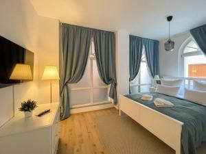 a bedroom with a bed and a large window at ApartOne Altstadt-Apartments in Bautzen
