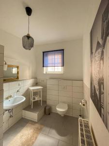 a white bathroom with a sink and a toilet at ApartOne Altstadt-Apartments in Bautzen