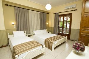 a hotel room with two beds and a table at La Luna in Kala Nera
