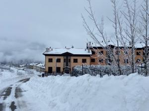 ein schneebedecktes Haus neben einer Straße in der Unterkunft Duplex nuovo e grazioso in Capracotta