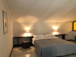 a bedroom with a bed and two lights on the wall at Hotel Kristall in Orvieto