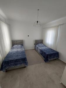 two beds in a white room with two bedsvisor at Bodrum Gündoğan Koyu Havuzlu Site in Bodrum City +33 photos