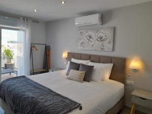 1 dormitorio con 1 cama blanca grande y 2 lámparas en Casa Paula Apartments, en Lagos