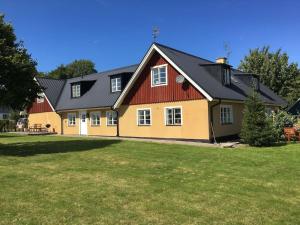 ein großes gelbes und rotes Haus mit einem Hof in der Unterkunft Gladsax Gamla Gård in Simrishamn