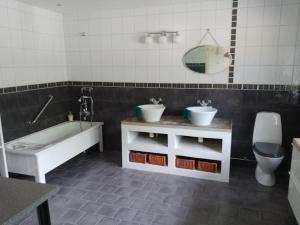 ein Badezimmer mit einer Badewanne, einem Waschbecken und einem WC in der Unterkunft Gladsax Gamla Gård in Simrishamn