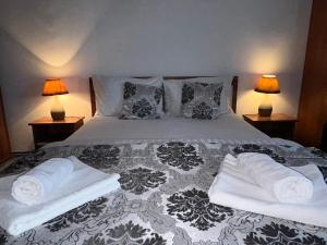 ein Schlafzimmer mit einem Bett mit Handtüchern und zwei Lampen in der Unterkunft Amazing House Cazare in Sibiu