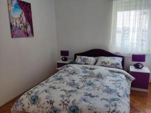 Un dormitorio con una cama con un edredón azul y blanco. en Apartman Novaković, en Bijeljina 9 fotos más