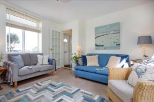 a living room with a blue couch and chairs at York Cottage in Sidmouth