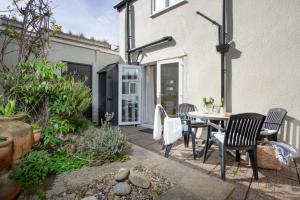 a patio with a table and chairs and a building at York Cottage in Sidmouth