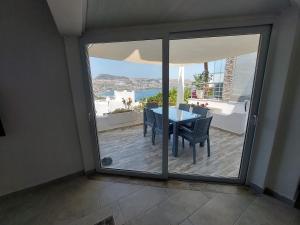 a room with a sliding glass door with a table and chairs at Bodrum Gündoğan Koyu Havuzlu Site in Bodrum City