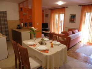 uma sala de jantar com uma mesa e uma sala de estar em Apartman Stella em Fasana