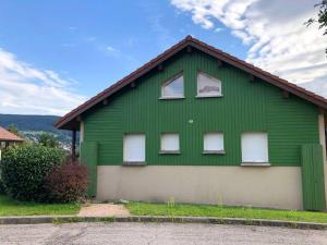 a green house with white windows on top of it at Les chênes Rouges 4/p in Gérardmer