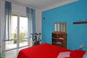 a bedroom with a red bed and a window at La Porta delle 5 Terre Trilocali in Bonassola