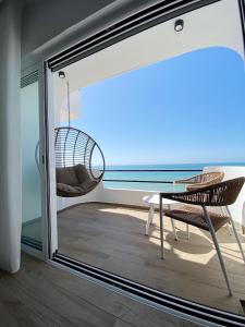 a room with a balcony with a swing and a chair at Front Sea Apartment Albufeira in Albufeira