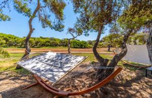 a hammock under a tree in a park at Infinito Resort in Specchiolla 